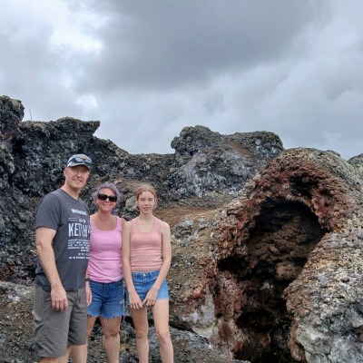a man standing next to a rock