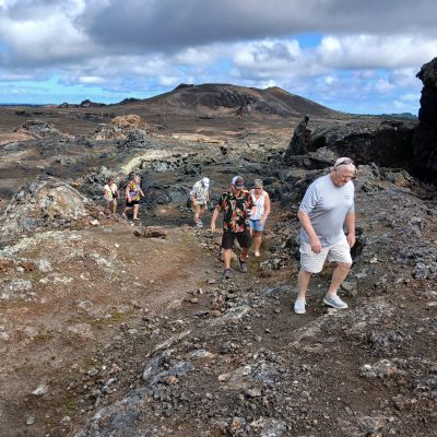 a group of people walking down a dirt road