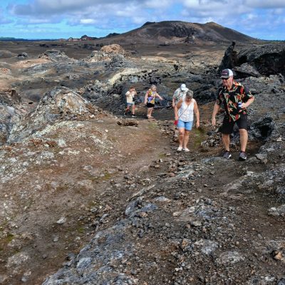 a group of people standing on a rocky hill